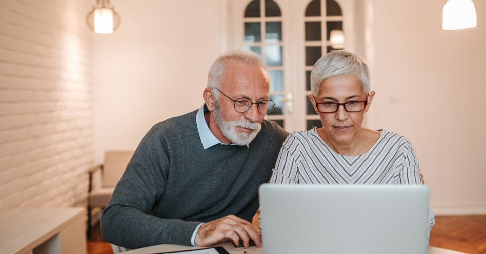Senior couple looking at laptop screen